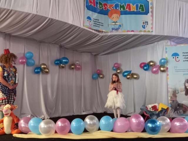 Występ dziewczynki recytującej wiersz na scenie