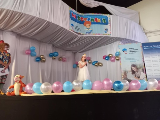 Występ dziewczynki recytującej wiersz na scenie