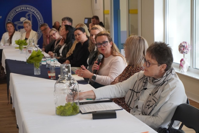 Uczestniczka debaty zadaje pytanie przez mikrofon