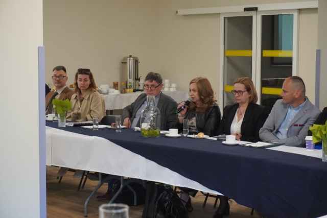 Uczestniczka debaty zadaje pytanie przez mikrofon