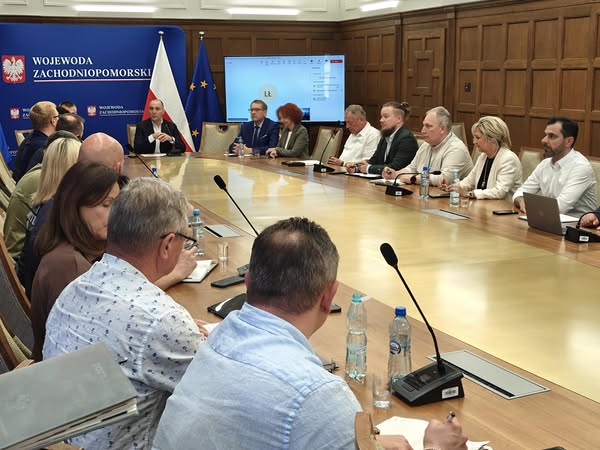 Grupa ludzi siedzących przy stole podczas obrad.