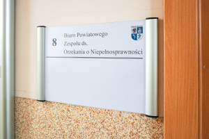 Tabliczka przy biurze Buira Powiatowego Zespołu ds. Orzekania o Niepełnosprawności